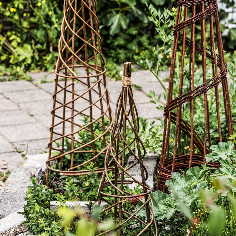 Twee gevlochten plantensteunen in de tuin